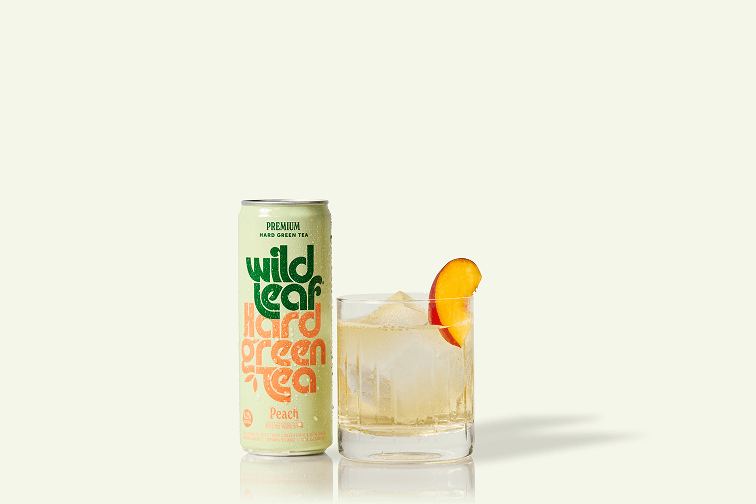 A can and glass of Peach Wild Leaf Hard Green Tea
