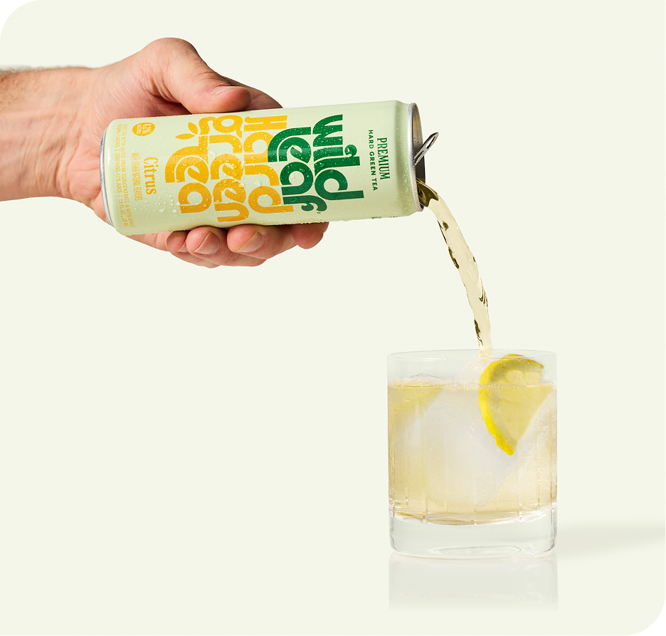 Citrus Wild Leaf Hard Green Tea being poured from a can into a glass