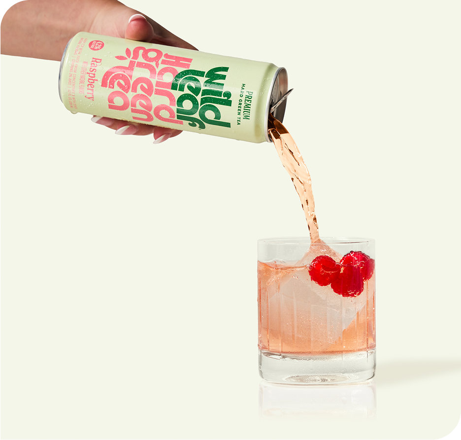 Raspberry Wild Leaf Hard Green Tea being poured from a can into a glass