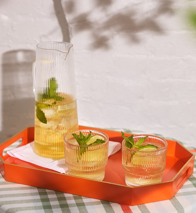 A tray with a pitcher and two glasses filled with Wild Leaf Hard Green Tea
